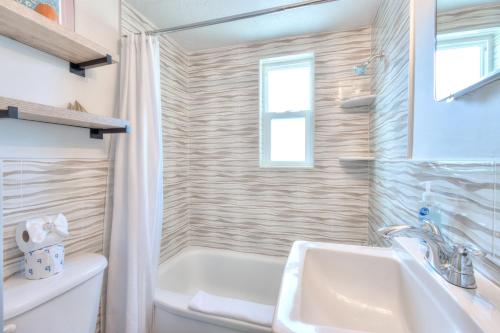 a bathroom with a sink and a tub and a toilet at Tropic Terrace #15 - Beachfront Rental condo in St. Pete Beach