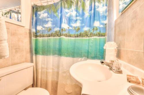 een badkamer met een wastafel, een toilet en een raam bij Tropic Terrace #16 - Beachfront Rental apts in St Pete Beach