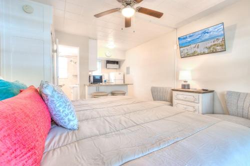 1 dormitorio con 1 cama grande y ventilador de techo en Tropic Terrace #18 - Beachfront Rental condo, en St Pete Beach