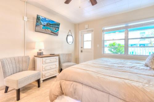 1 dormitorio con 1 cama, 1 silla y 1 ventana en Tropic Terrace #18 - Beachfront Rental condo, en St Pete Beach