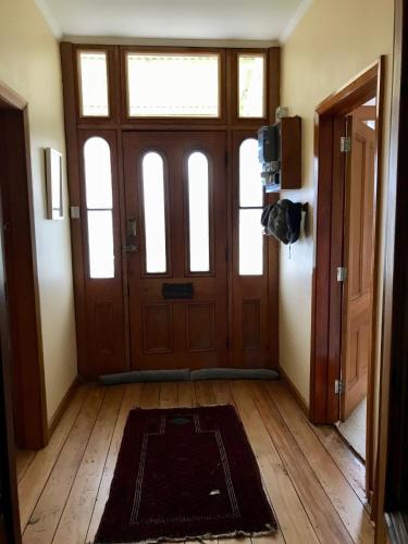 an empty room with a door and a rug on the floor at The Old Vicarage in Reefton