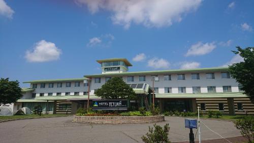 a large white building with a sign in front of it at Hotel Tetoraresort Tokachigawa in Otofuke