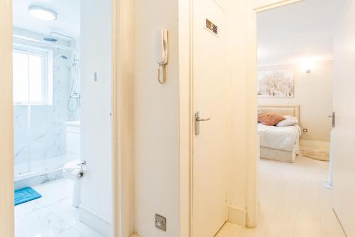 a bathroom with a door leading to a bedroom at Modern apartment close to central London (zone 2) in London