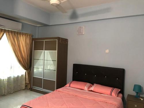 Un dormitorio con una cama con sábanas rojas y una ventana en HOMESTAY MSA D'KIJAL, en Kampong Kemaman