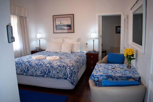 um quarto com uma cama e uma cadeira em Boathouse Bunbury Bed & Breakfast em Bunbury