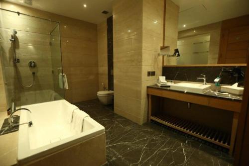 y baño con bañera, lavabo y aseo. en The Umrao en Nueva Delhi