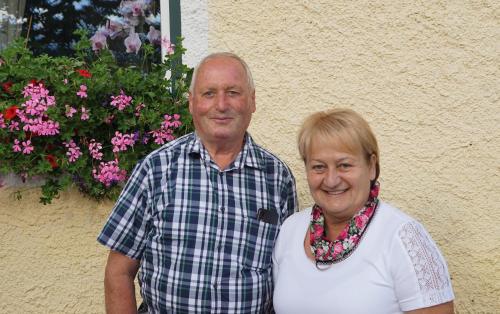 a man and a woman standing in front of flowers at Ferienhaus Hochfelner in Sankt Marein bei Knittelfeld