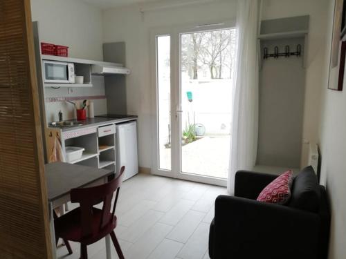 a living room with a kitchen and a table and chairs at 33 Ter Bon pied à terre in La Rochelle