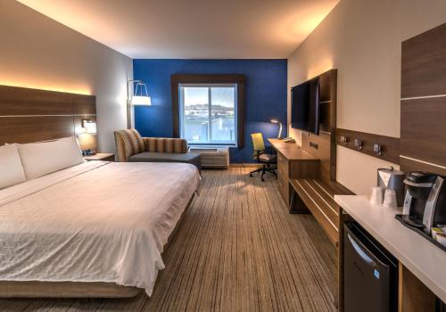 a hotel room with a large bed and a desk at Holiday Inn Express Hotel & Suites Minden by IHG in Minden
