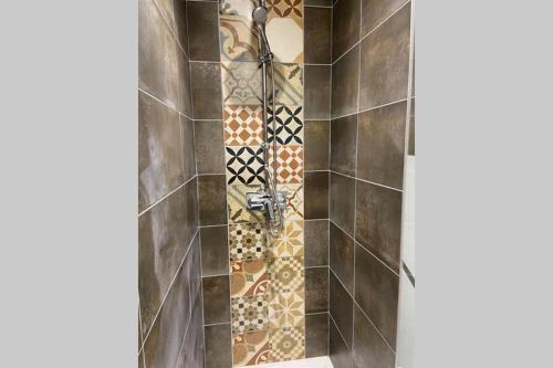 y baño con ducha y azulejos de mosaico. en Urban Loft en Vesoul