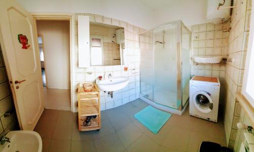 uma casa de banho com um lavatório e uma máquina de lavar roupa em casa maya em Recco