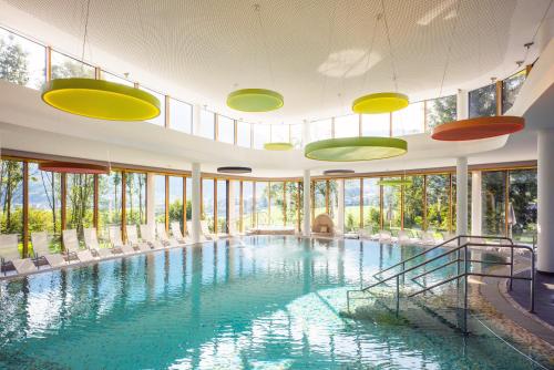 una gran piscina con sillas y ventanas en DAS SIEBEN - Adults Only en Bad Häring