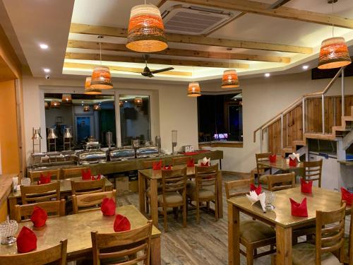 a restaurant with wooden tables and chairs and red bows at D's Casa - A Unique Spanish Boutique House in McLeod Ganj