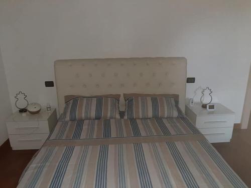 sypialnia z dużym łóżkiem i 2 szafkami nocnymi w obiekcie APPARTAMENTO LAKE GARDA ibiscus di Francia w mieście Desenzano del Garda