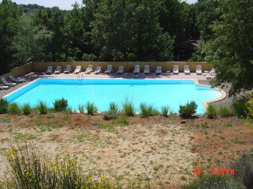 - une grande piscine avec des chaises et un bouquet dans l'établissement Gite des Ocres, à Villars