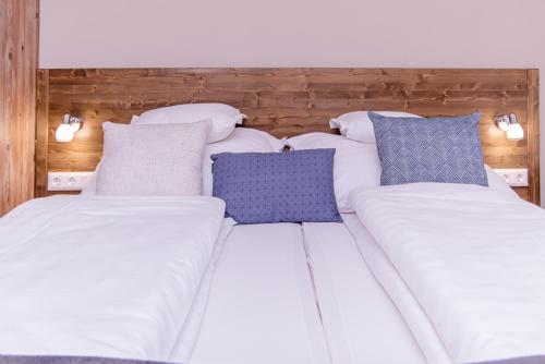 two beds with blue and white pillows on them at Három a Kislány Panzió in Hévíz