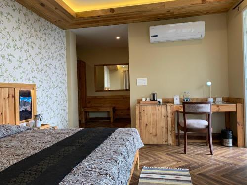 a bedroom with a bed and a desk with a chair at D's Casa - A Unique Spanish Boutique House in McLeod Ganj