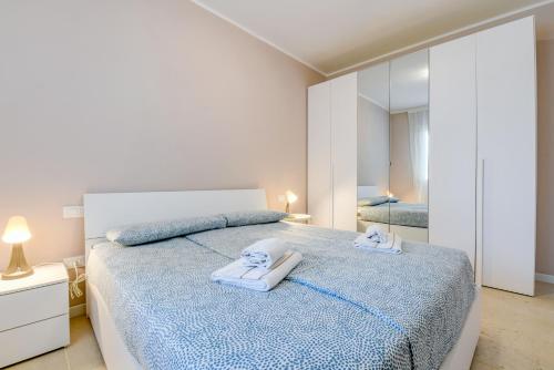 a bedroom with a large bed with towels on it at Le Ville della Romantica in Manerba del Garda
