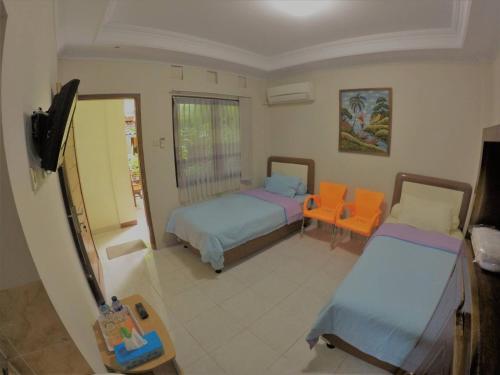 a room with two beds and a flat screen tv at Sabana Homestay in Yogyakarta