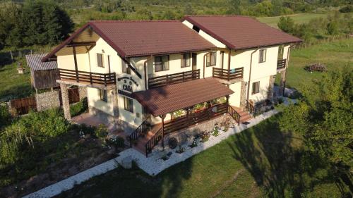 an aerial view of a house with a roof at Pensiunea Gradinarilor cu ciubăr și stație de încărcare electrică auto in Comăneşti