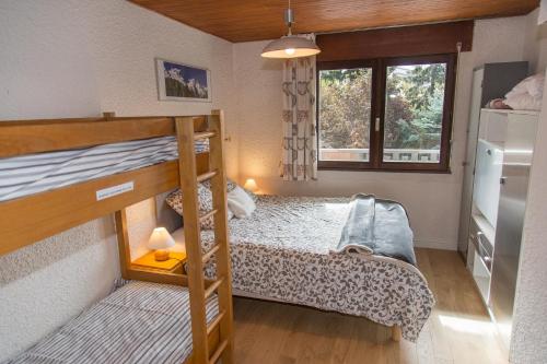 une chambre avec deux lits superposés et une fenêtre dans l'établissement JANDRI 4 Appartement 6 personnes -38860 Les 2 Alpes - Pied des pistes, à Les Deux Alpes