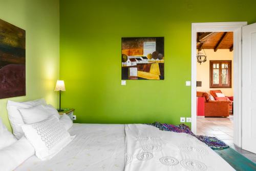 a green bedroom with a white bed and a green wall at Beachfront Villa Meliti in Ágios Matthaíos