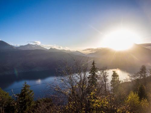 a view of a lake with the sun in the sky at Apartment Enzian mit Mitbenutzung SPA & Wellness - GRIWA RENT AG in Beatenberg