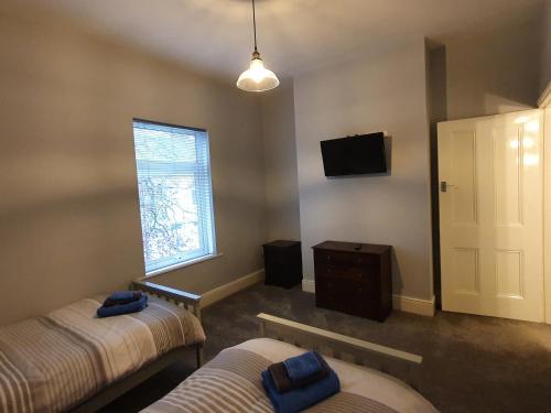 um quarto com duas camas e uma televisão e uma janela em The Shed em Darlington