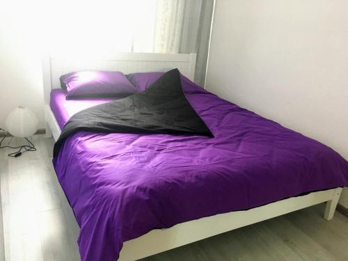 a bed with purple sheets and pillows in a bedroom at Loft 2кімнатні Апартаменти Сучасний ремонт WiFi in Chernihiv