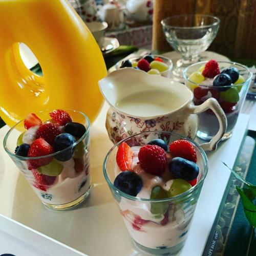 亨利昂泰晤士Handywater Cottages的桌子上放着两杯水果和一杯酸奶。