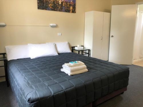 Un dormitorio con una cama con una toalla. en Fairway Lodge Motel, en Kempsey