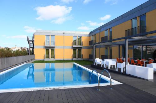 a swimming pool on the roof of a building at Hotel 3K Faro Aeroporto in Faro