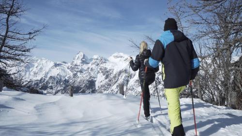 a man and a woman on skis in the snow at Laube35 Central City Apartments in Vipiteno