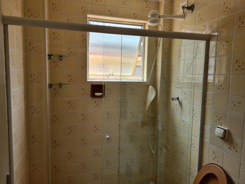uma casa de banho com um chuveiro e uma janela em Apartamento vista mar Praia Grande em Praia Grande