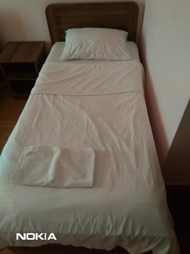 a bed with white sheets and pillows on it at NNN Tourist in Kutaisi