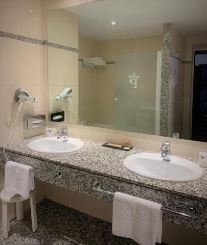 a bathroom with two sinks and a large mirror at Parador de Vilalba in Villalba