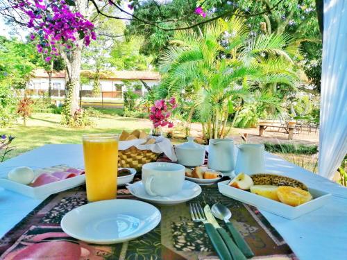 una mesa con platos de comida y un vaso de zumo de naranja en Santa Maria Hotel en Santa María