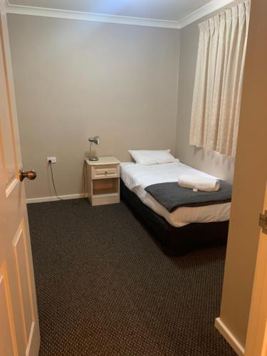 a small bedroom with a bed and a night stand at Waratah in Albany