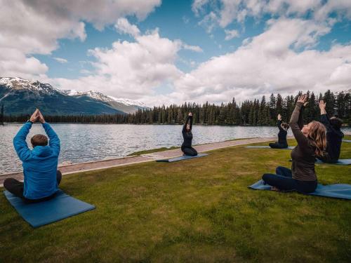 a group of people doing yoga by the water at Fairmont Jasper Park Lodge in Jasper