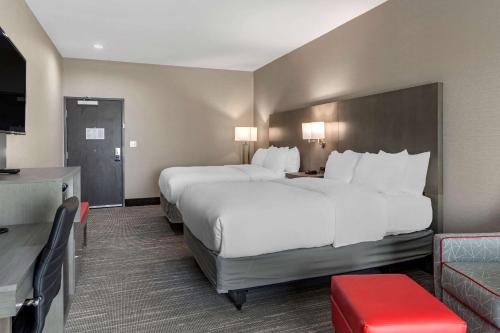 a hotel room with two beds and a television at Comfort Inn & Suites in Olive Branch