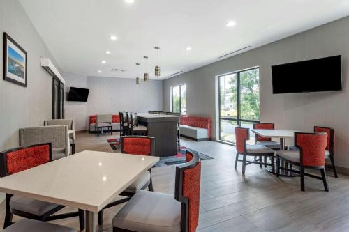 a waiting room with tables and chairs and a tv at Comfort Inn & Suites in Olive Branch