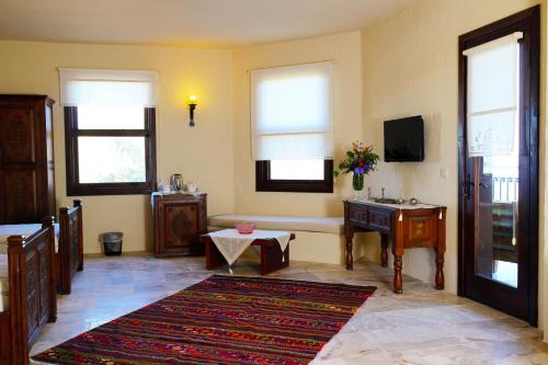 uma sala de estar com uma televisão, uma mesa e janelas em Room in BB - Exclusive and Romantic Boutique Hotel em Fethiye