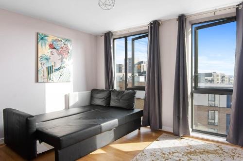 Una sala de estar con un sofá y una ventana grande. en Spacious & Cosy, Netflix, Parking, Colindale Station, en Hendon