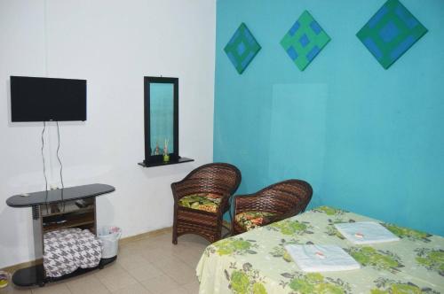 a room with a table and two chairs and a television at Hospedaria Solar De Morretes in Morretes