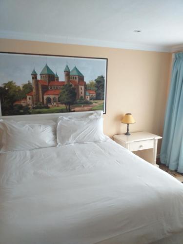 ein weißes Bett mit einem Bild eines Schlosses in der Unterkunft Alpine Inn in George