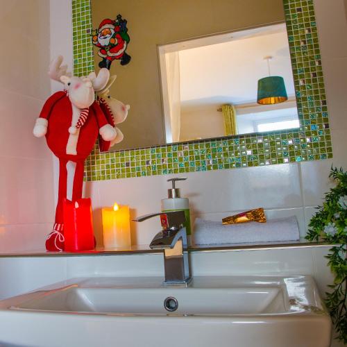a bathroom sink with a santa claus toy next to a mirror at Ceim house, Restful rural home Gap of dunloe, Killarney in Derrylea