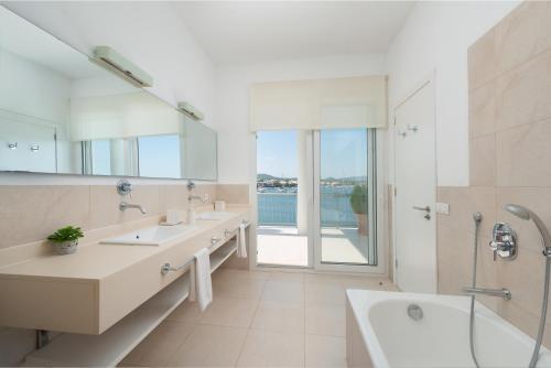 a bathroom with two sinks and a tub and a shower at Villa Can Marilla in Portocolom