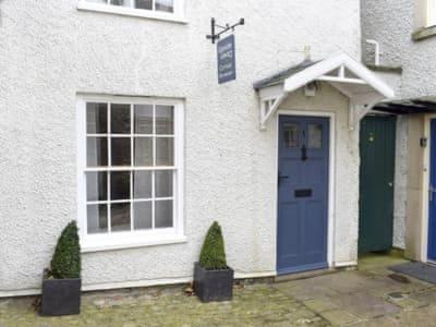 a white house with a blue door and a window at Upside Down Cottage in Richmond