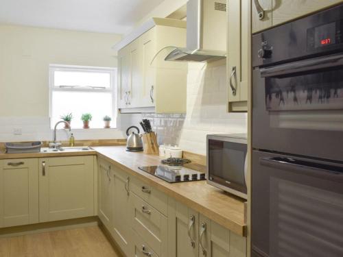 a kitchen with a sink and a stove top oven at Upside Down Cottage in Richmond