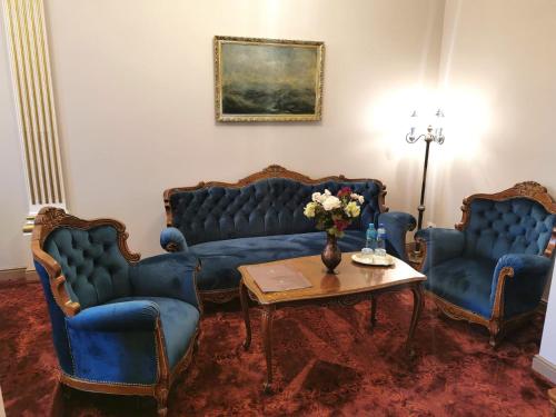 a living room with two blue couches and a table at Grand Hotel Traian in Iaşi
